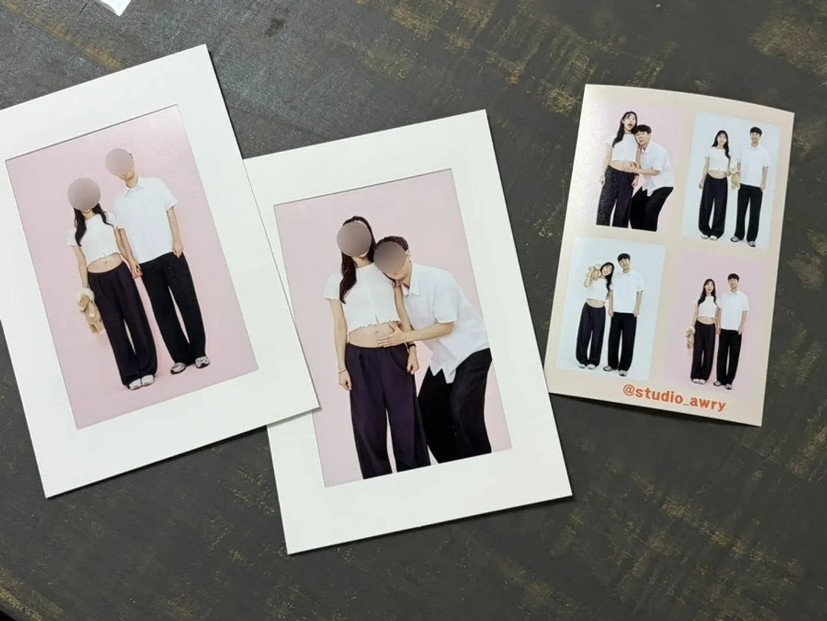 Couple's maternity photo shot against a light pink backdrop