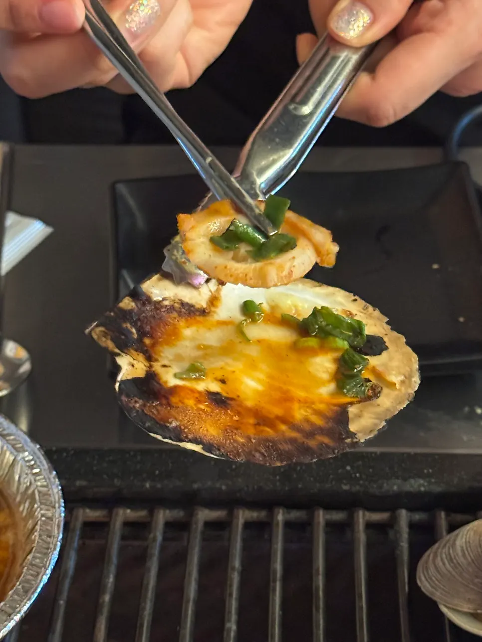 Grilled scallop topped with green onion