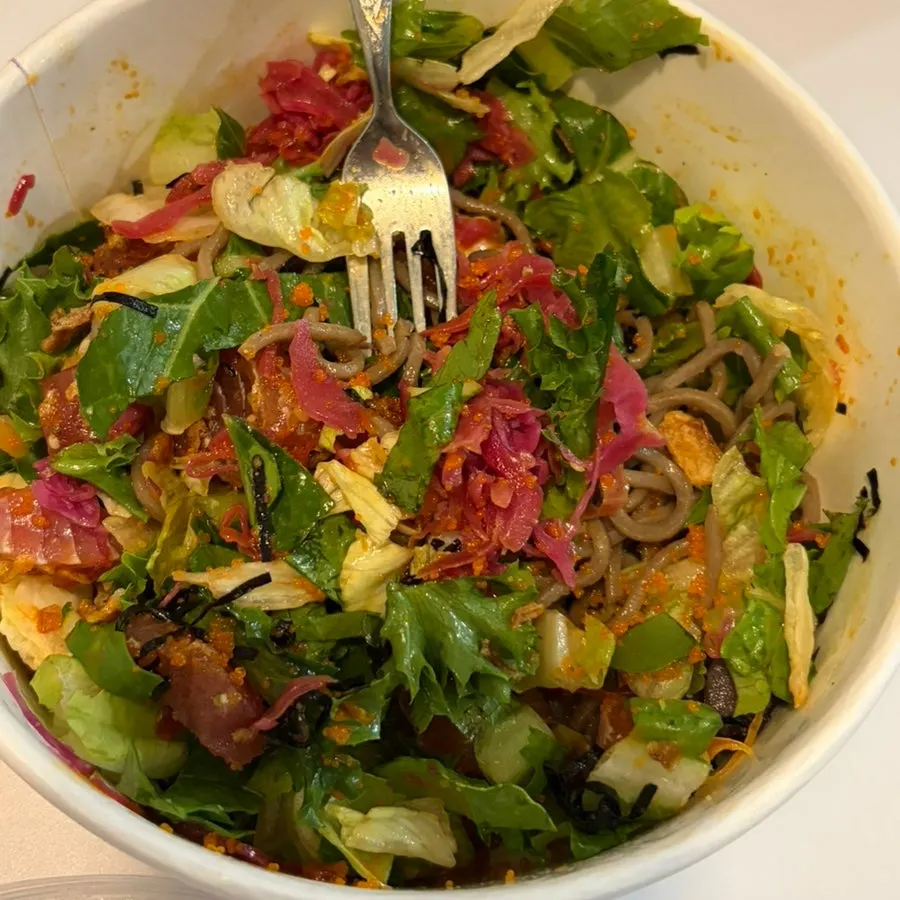A bowl of poke with buckwheat noodles mixed with tuna
