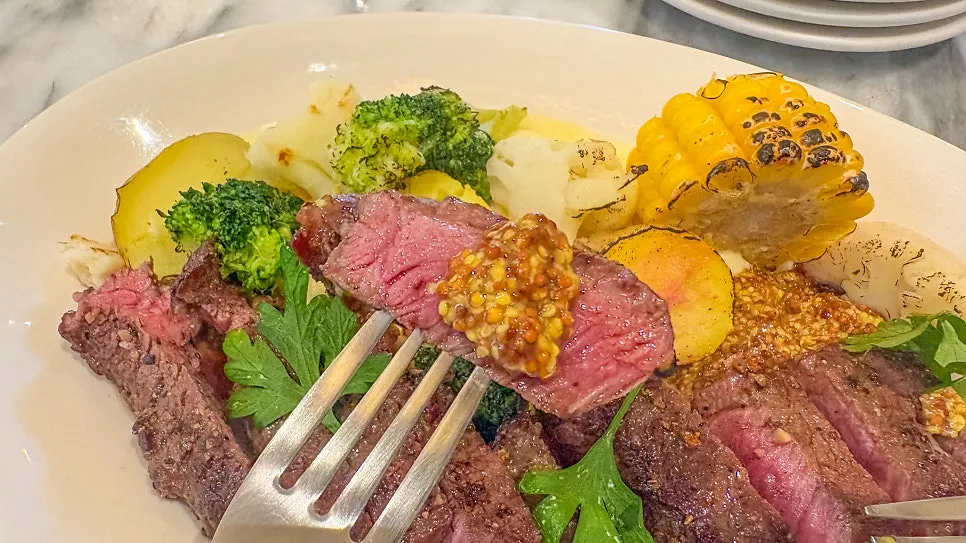 A piece of meat topped with mustard sauce