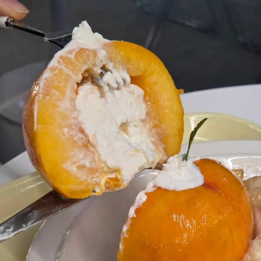 A whole peach cut in half revealing yogurt inside