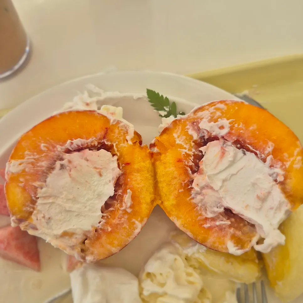 Greek yogurt revealed inside a halved peach