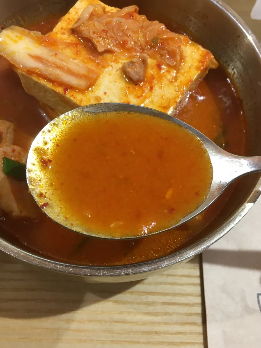 숟가락으로 떠올린 김치찌개 국물
