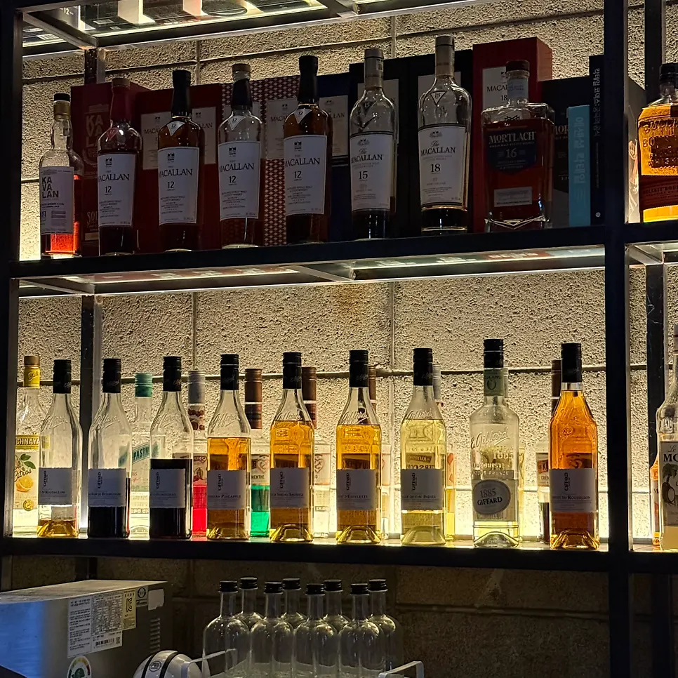 Bar counter at Bitters lined with cocktails and whisky