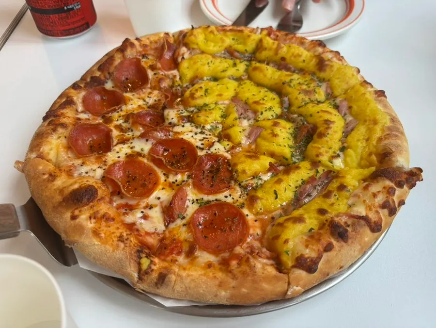 Piza separuh-separuh disajikan bersama zero cola