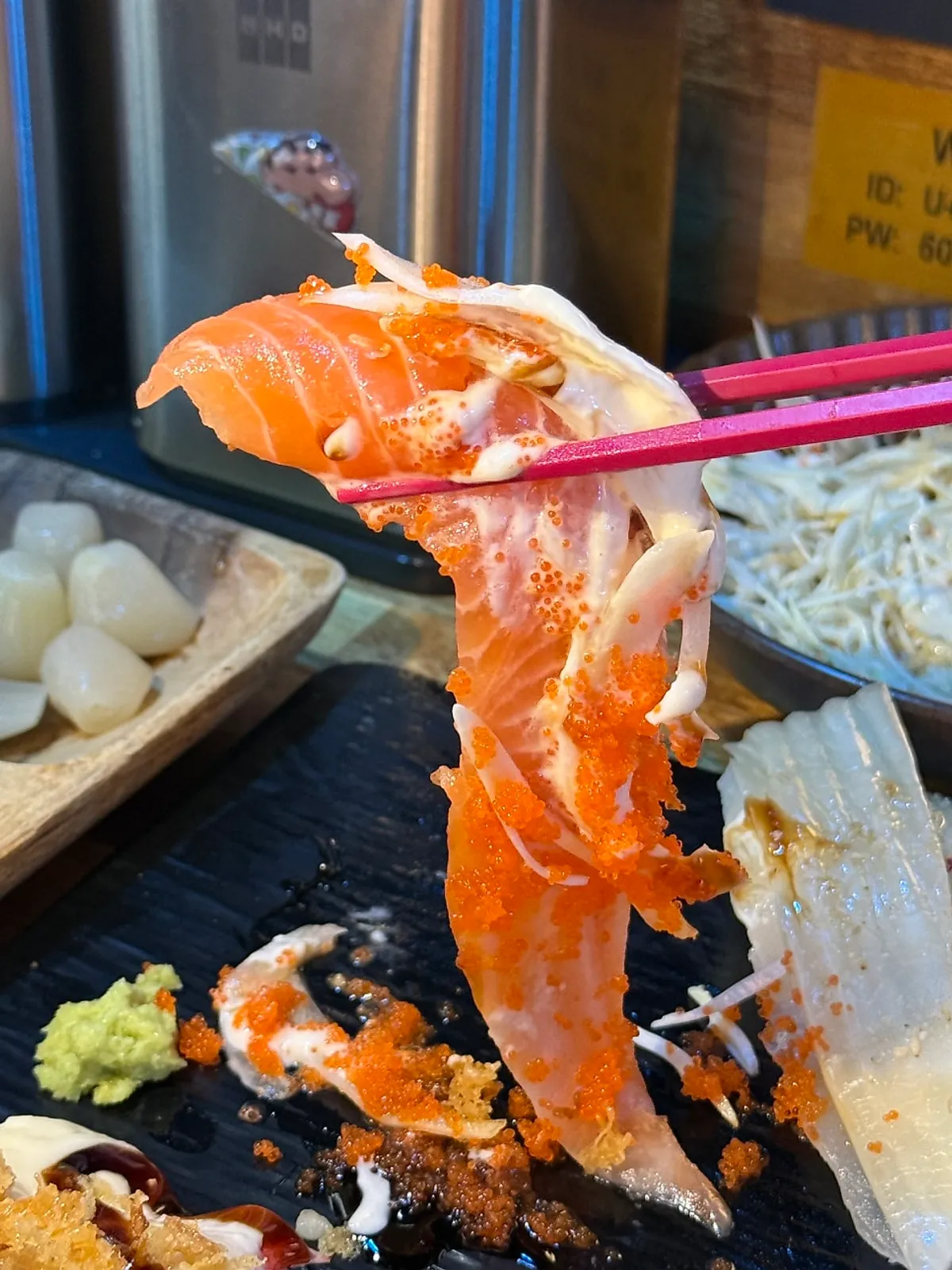 Salmon sushi with an extra-long tail hanging over the plate