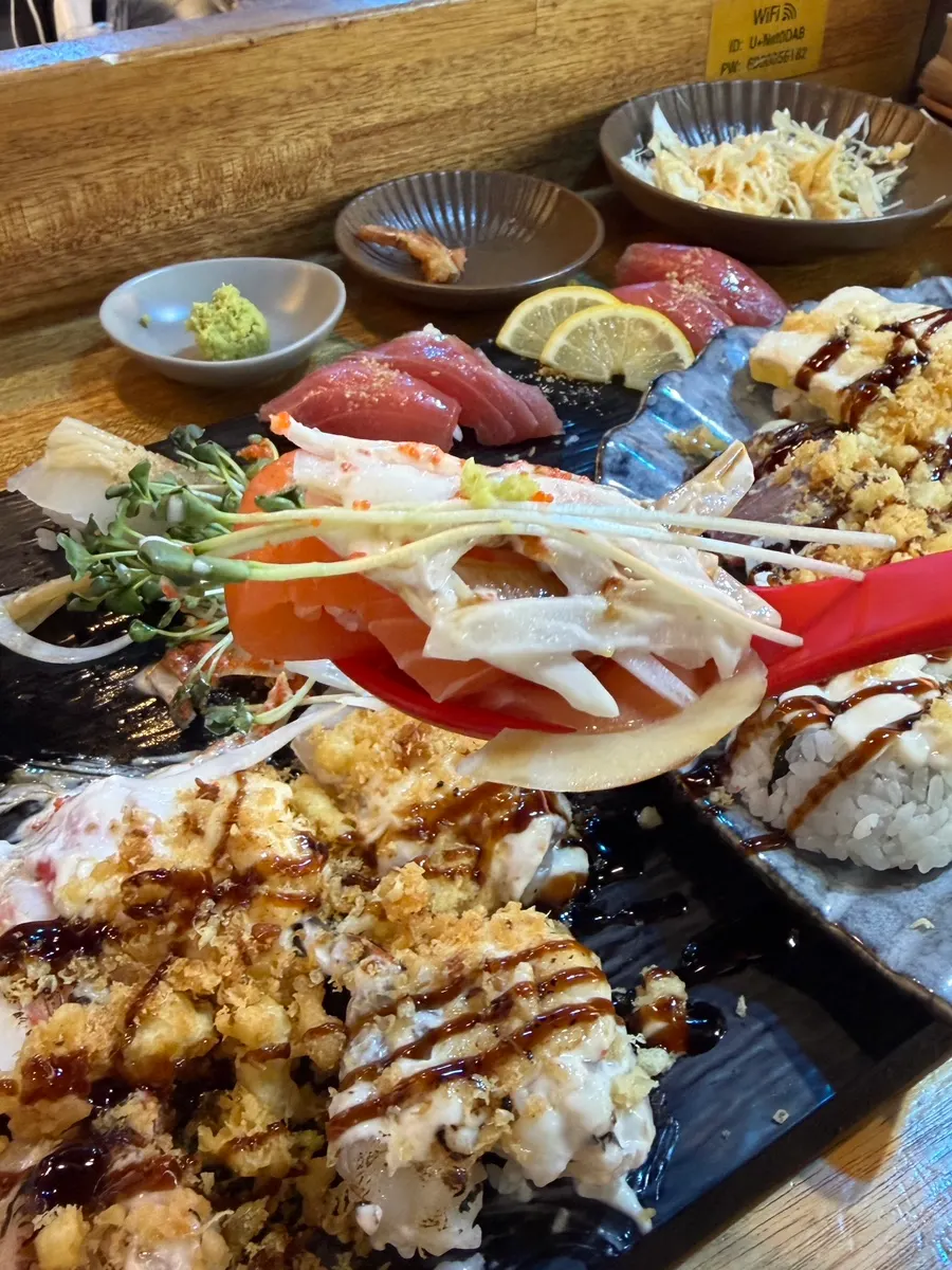 One piece of sushi with fish extending over the rice