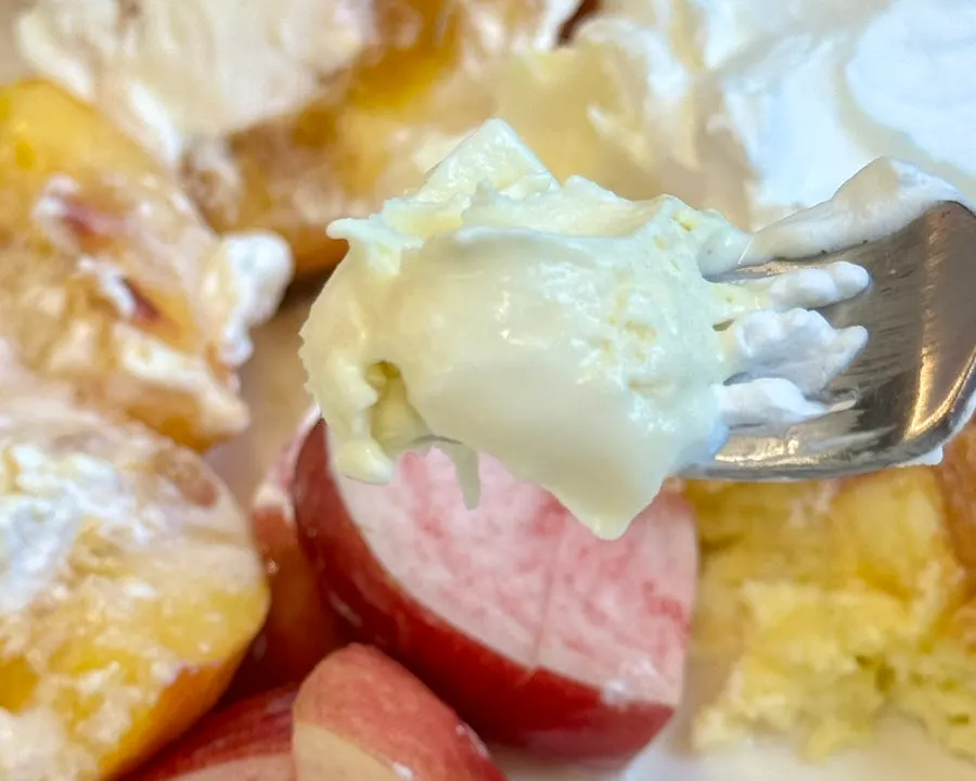 A spoonful with soufflé, peach, and ice cream together