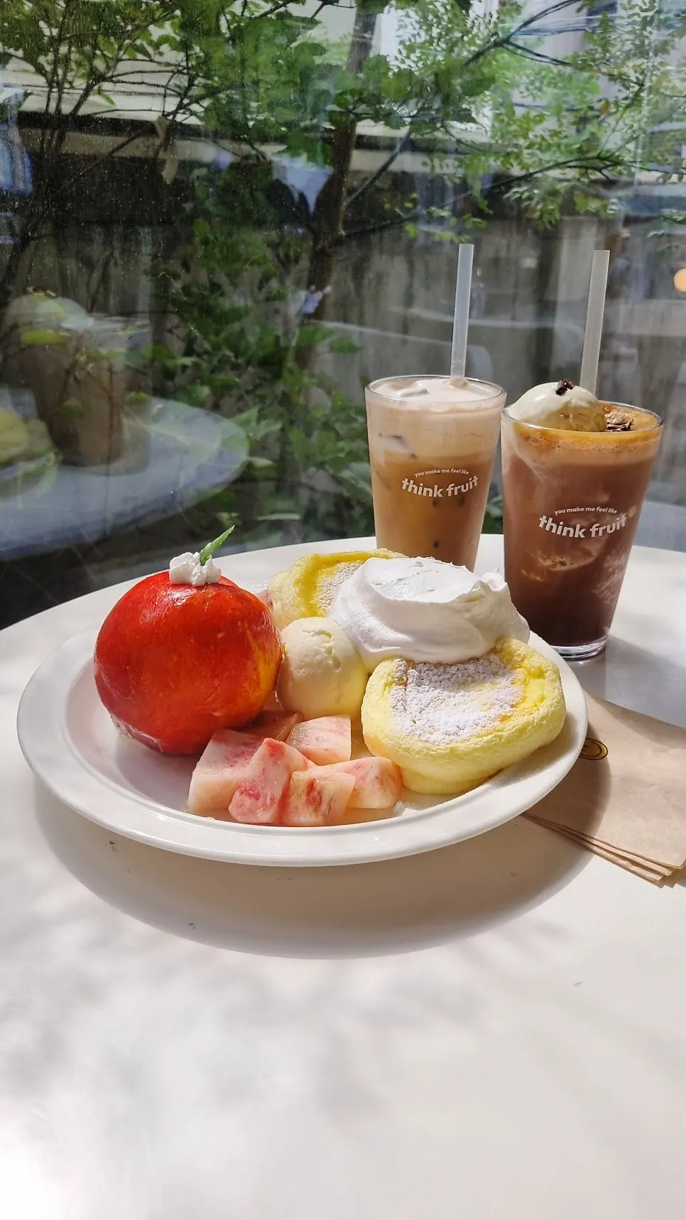Table set with peach soufflé and two drinks