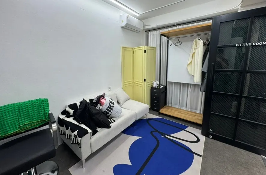 Fitting room dengan sofa dan gantungan baju