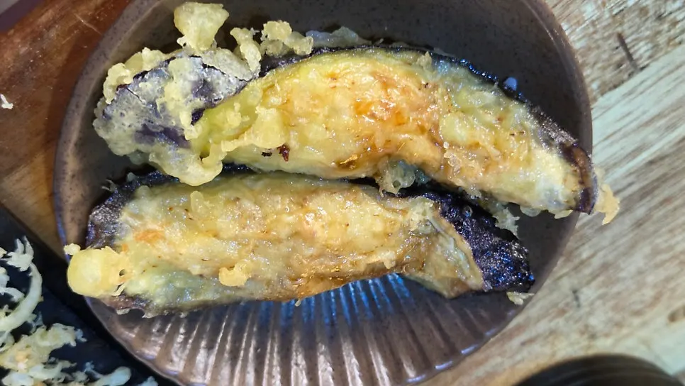 Complimentary fried eggplant sushi