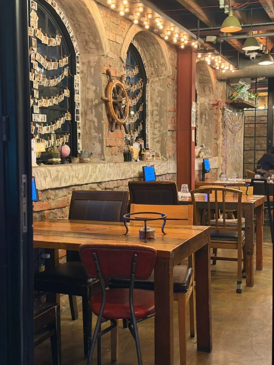 Interior with wooden tables and yellow lighting