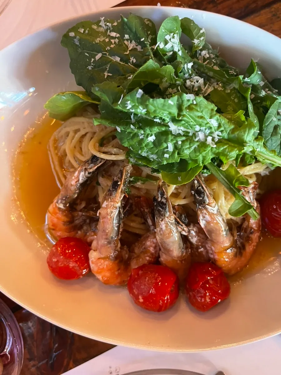 A bite of pasta with arugula and shrimp together