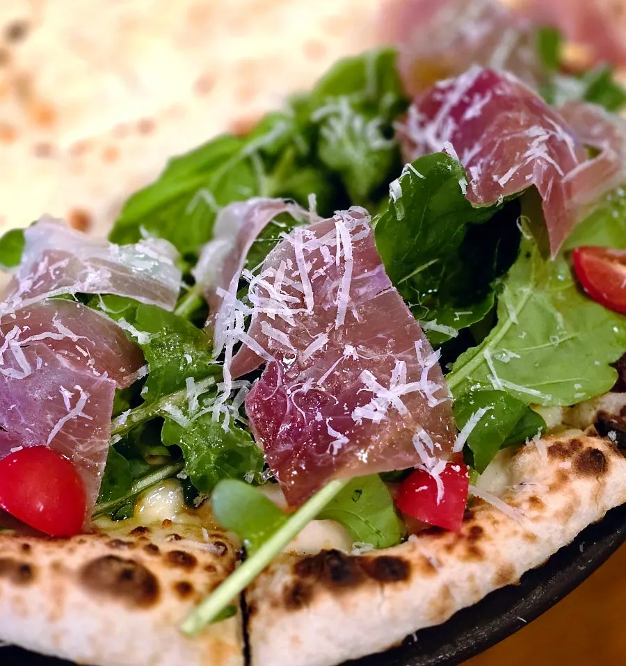 Half-and-half wood-fired pizza set on the candle tripod