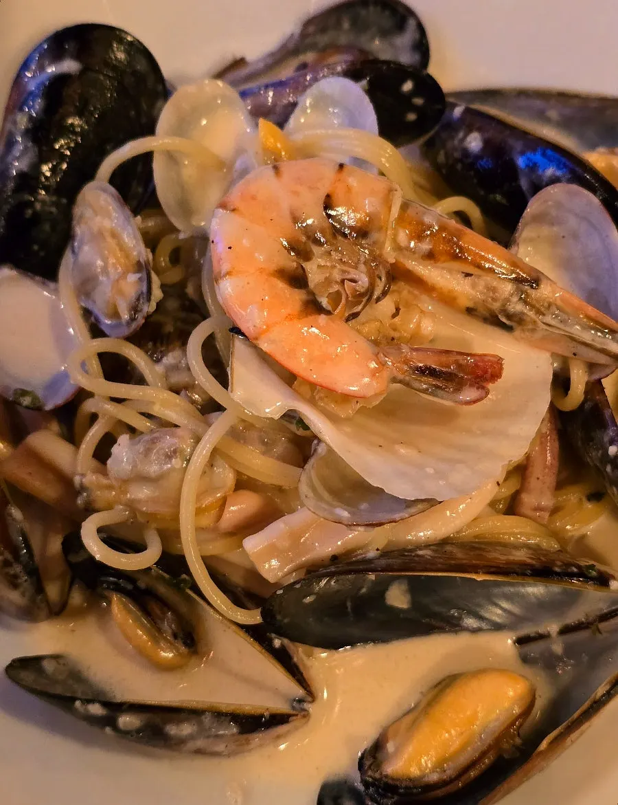 Seafood cream pasta topped with shrimp and clams