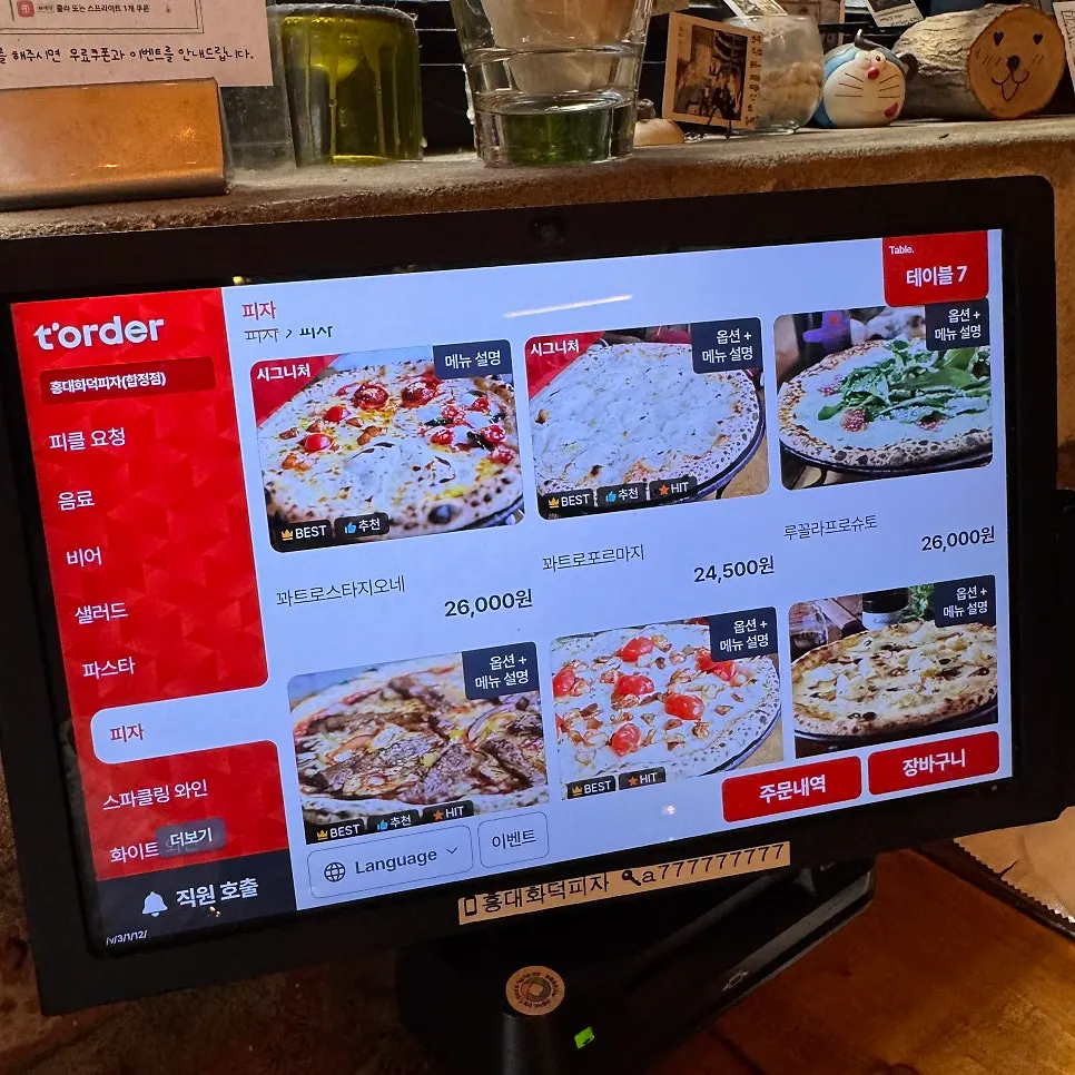 Corner of the restaurant with a sign about handmade dough and toppings