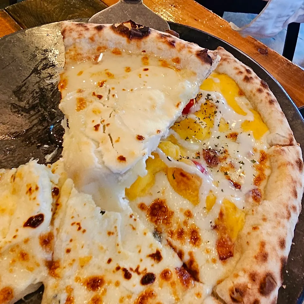 Slice of Quattro Formaggi pizza drizzled with honey