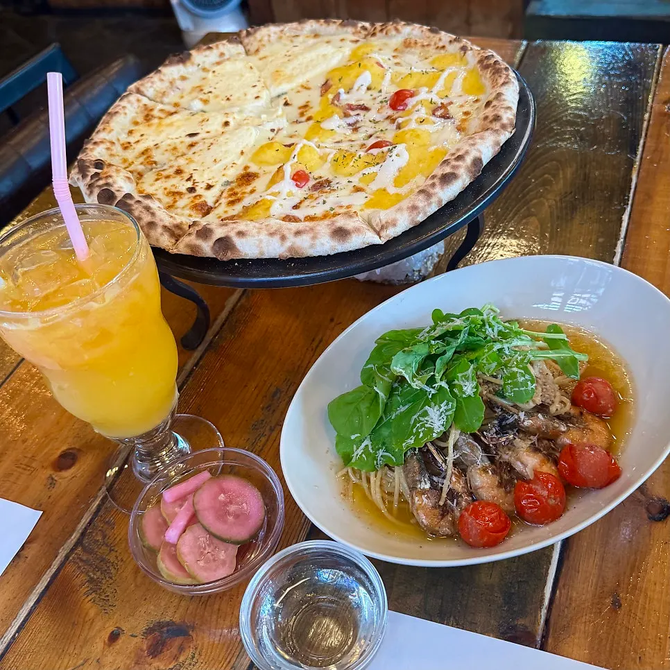 Table set with pizza and pasta being eaten together