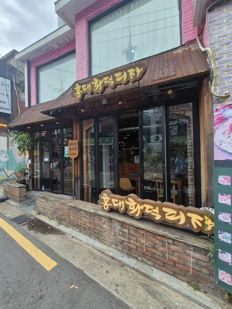 Exterior of Hongdae Hwadeok Pizza in an alley near Hapjeong Station
