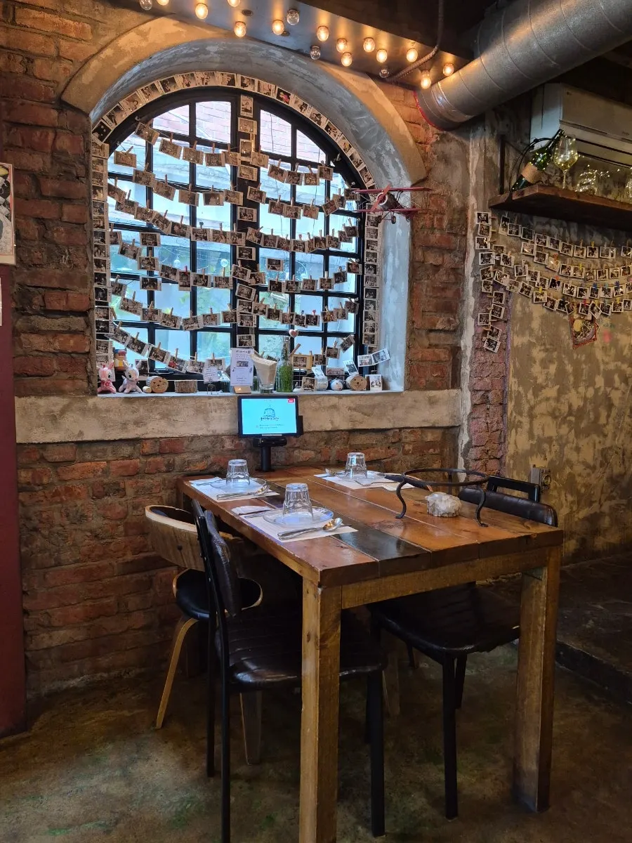 Interior of Hongdae Hwadeok Pizza with wood-toned lighting