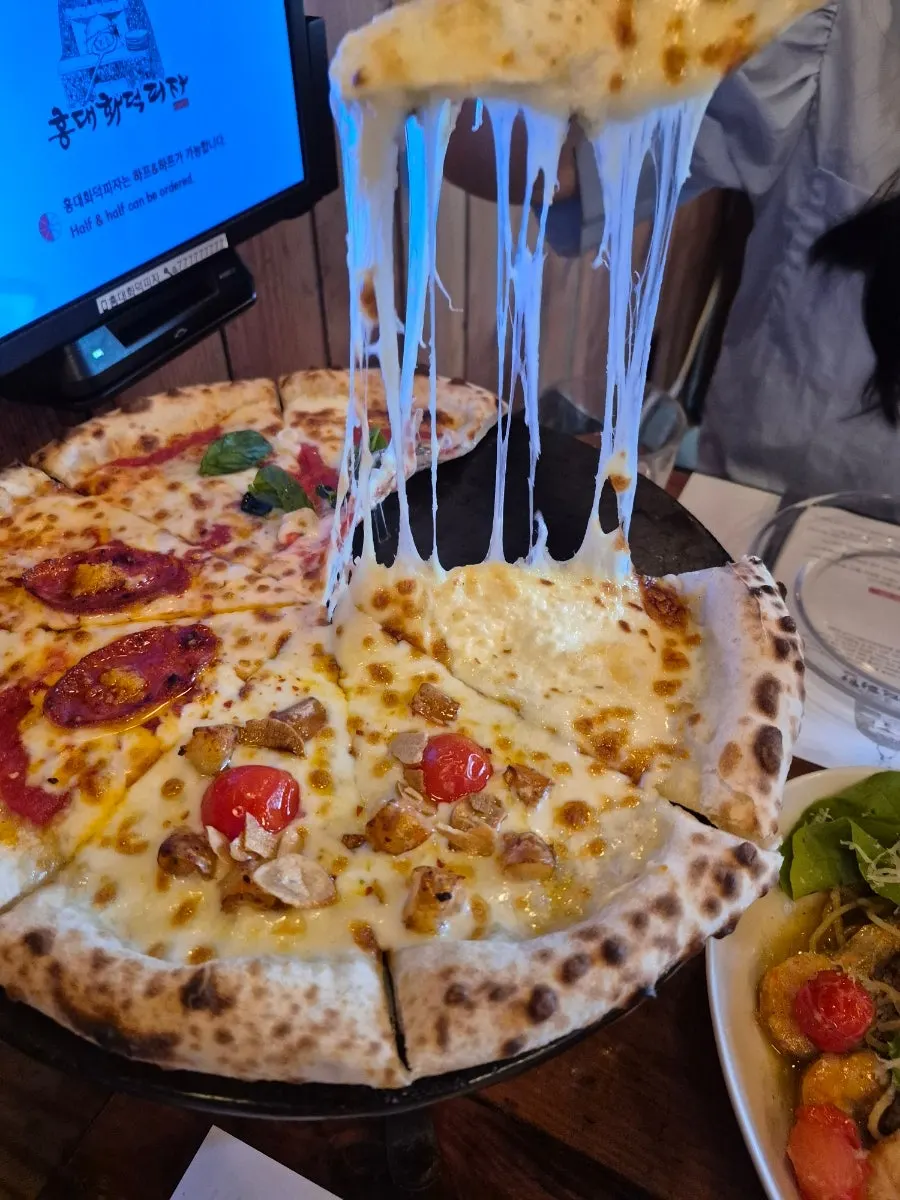 A slice of Quattro Formaggi with stretchy cheese