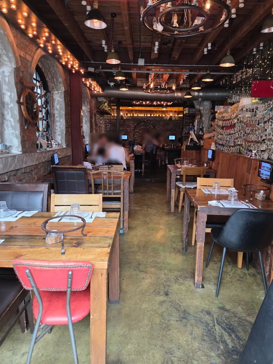 Indoor seating with 2-person and 4-person tables at Hongdae Hwadeok Pizza