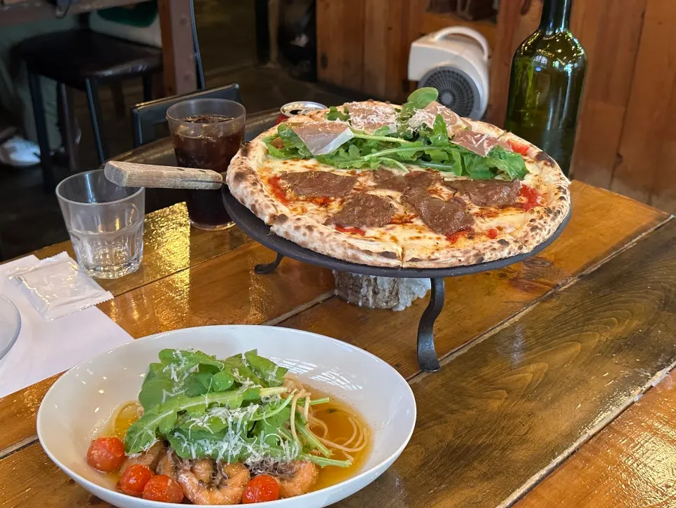 Half-and-half pizza and gamberi e rucola pasta on the table