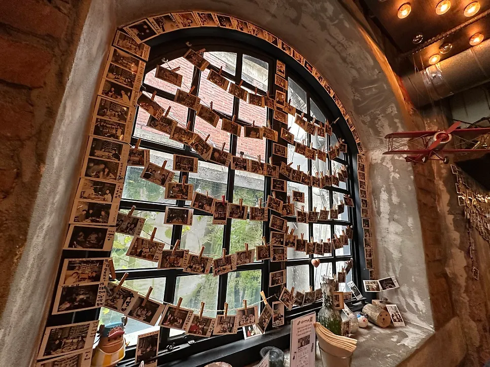 Wall of regulars' Polaroid photos hanging by the window
