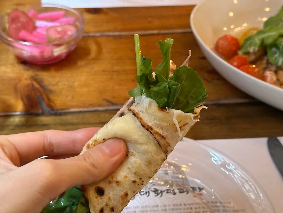 Rolling the dough with rucola and prosciutto to eat