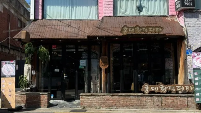 Brick exterior of Hongdae Hwadeok Pizza a short walk from Hapjeong Station