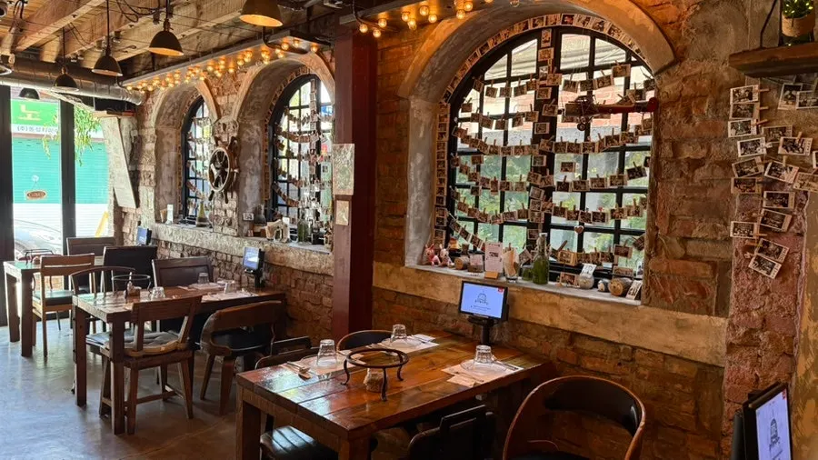 Interior of Hongdae Hwadeok Pizza decorated in wood tones and brick