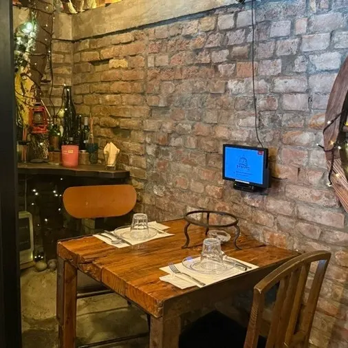 Photos on the wall alongside wood tables