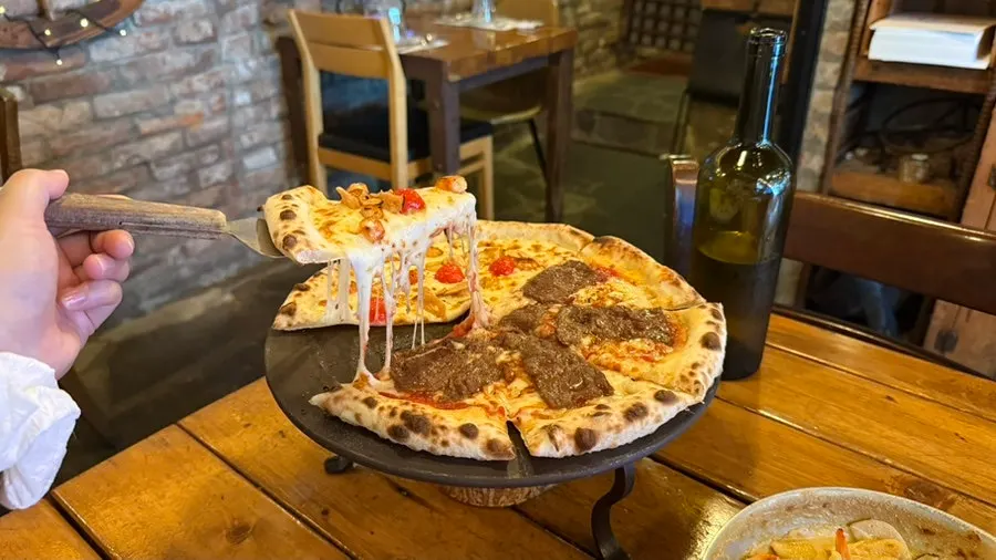 A slice of pizza with cheese stretching long