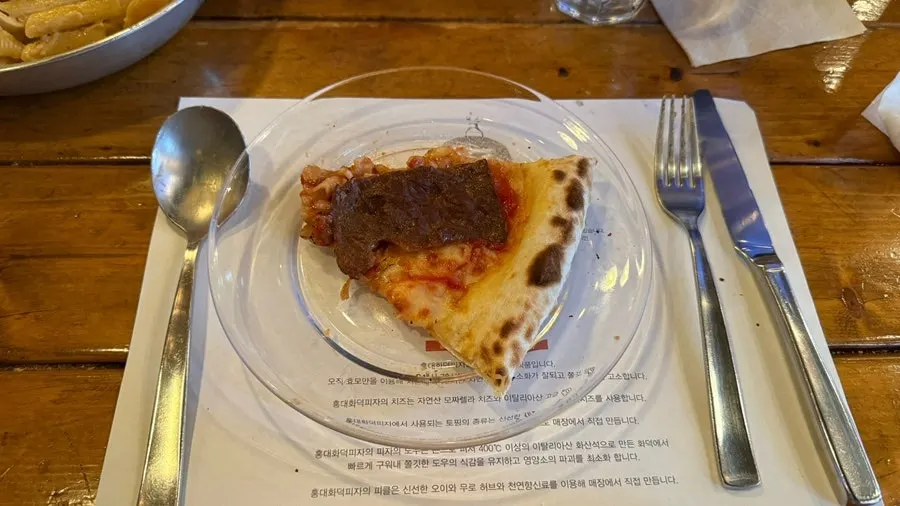 Manjo pizza topped with beef, onion, and paprika