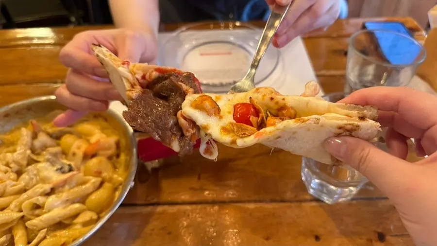 Half-and-half wood-fired pizza sliced and ready to eat