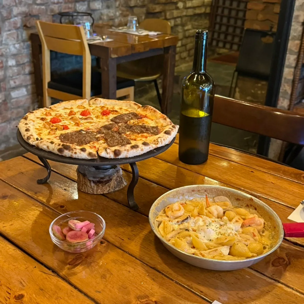 A table spread with half-and-half pizza and shrimp cream pasta together