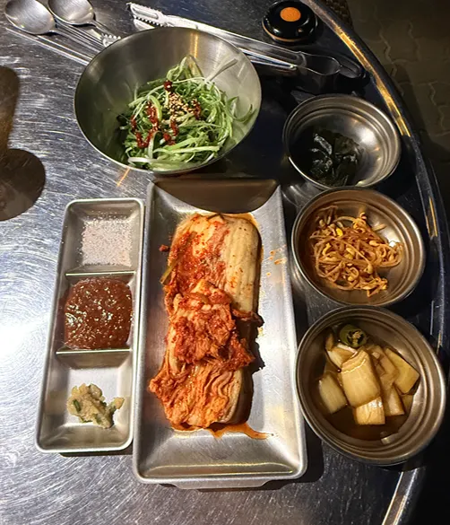Basic banchan spread including wild garlic greens, bean sprouts, and pickled onion