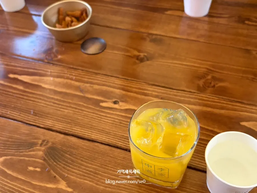 큰 잔에 담긴 주황빛 웰컴 드링크