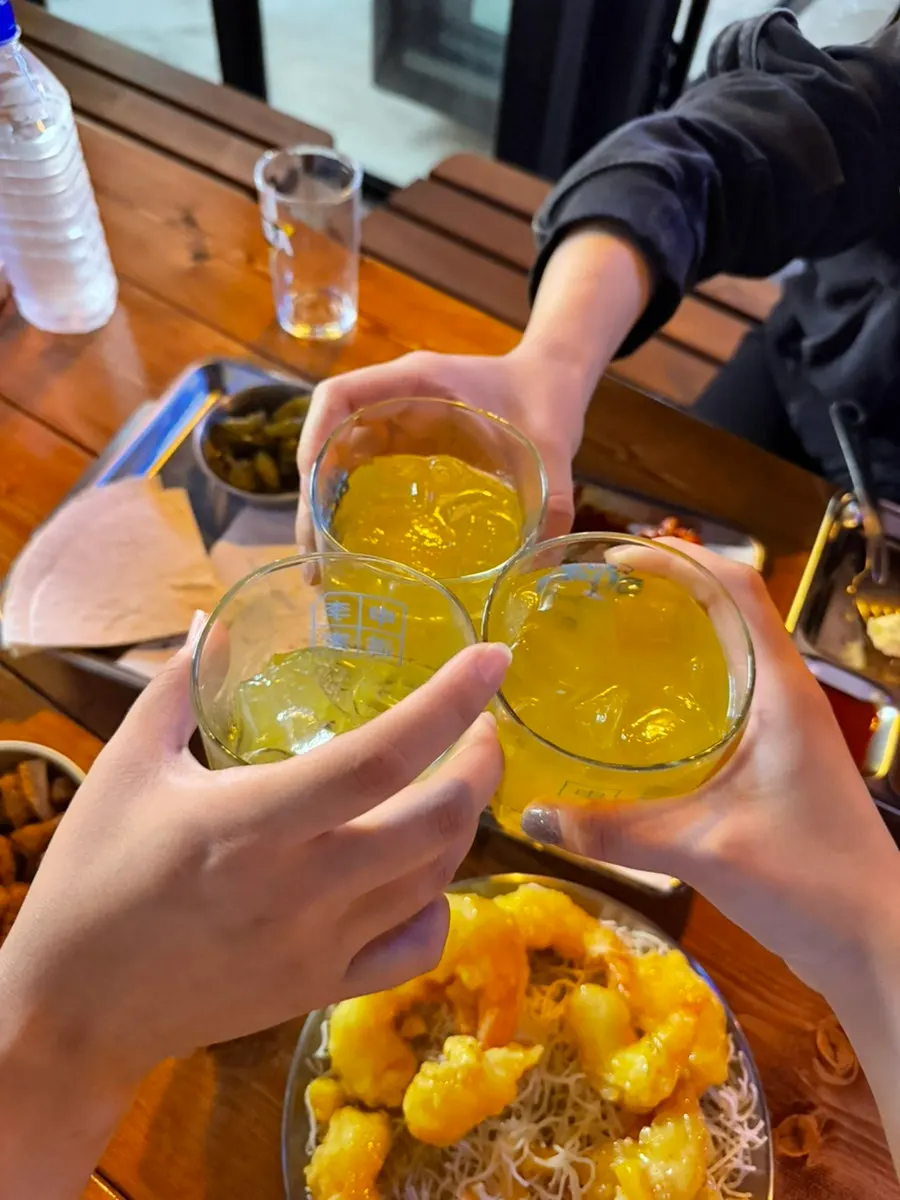 Glasses raised in a toast alongside the mango cream shrimp