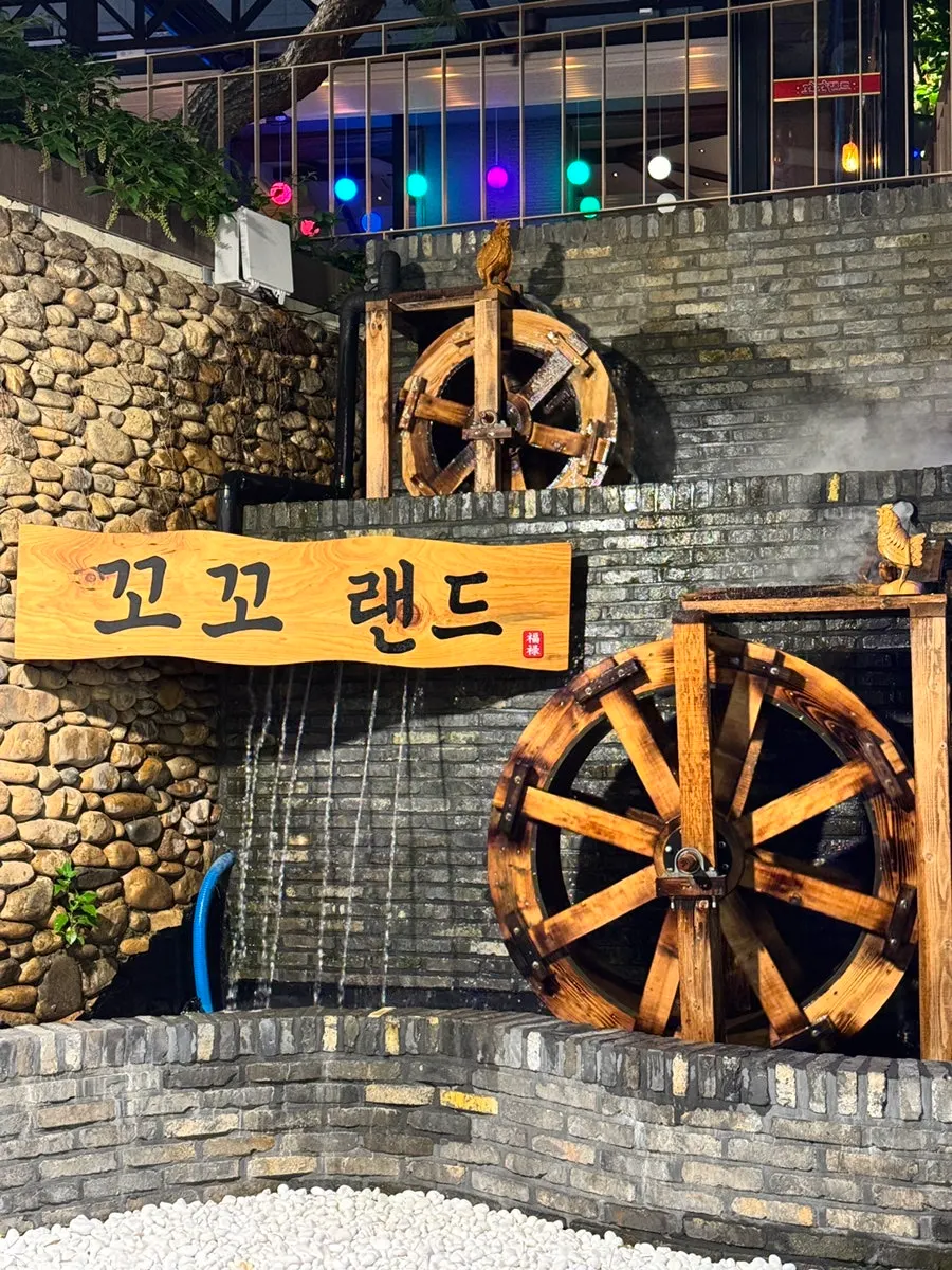 Entrance decorations with a waterwheel and carved wooden chickens
