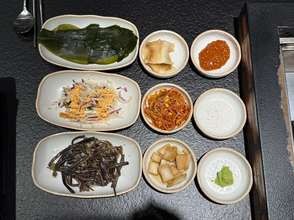 Table of basic side dishes including wild garlic and white kimchi