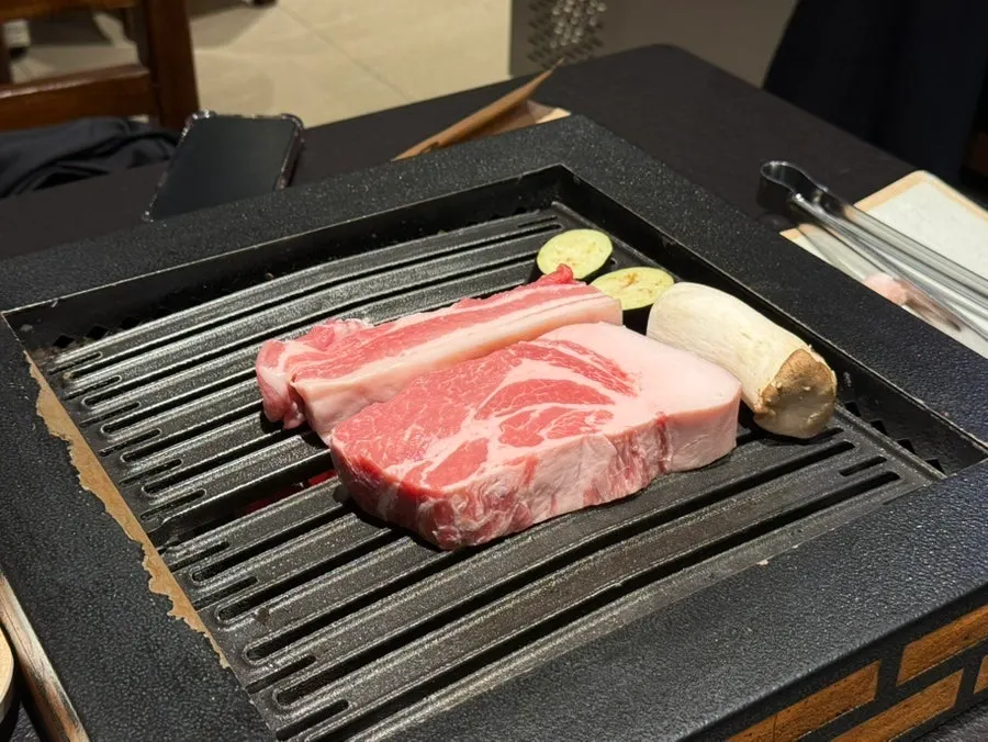 Thick premium thin-trimmed pork neck placed on the grill