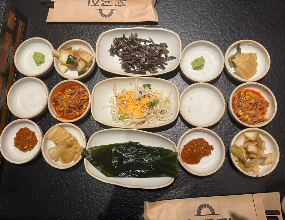 Banchan spread including aged kimchi and mountain garlic leaves