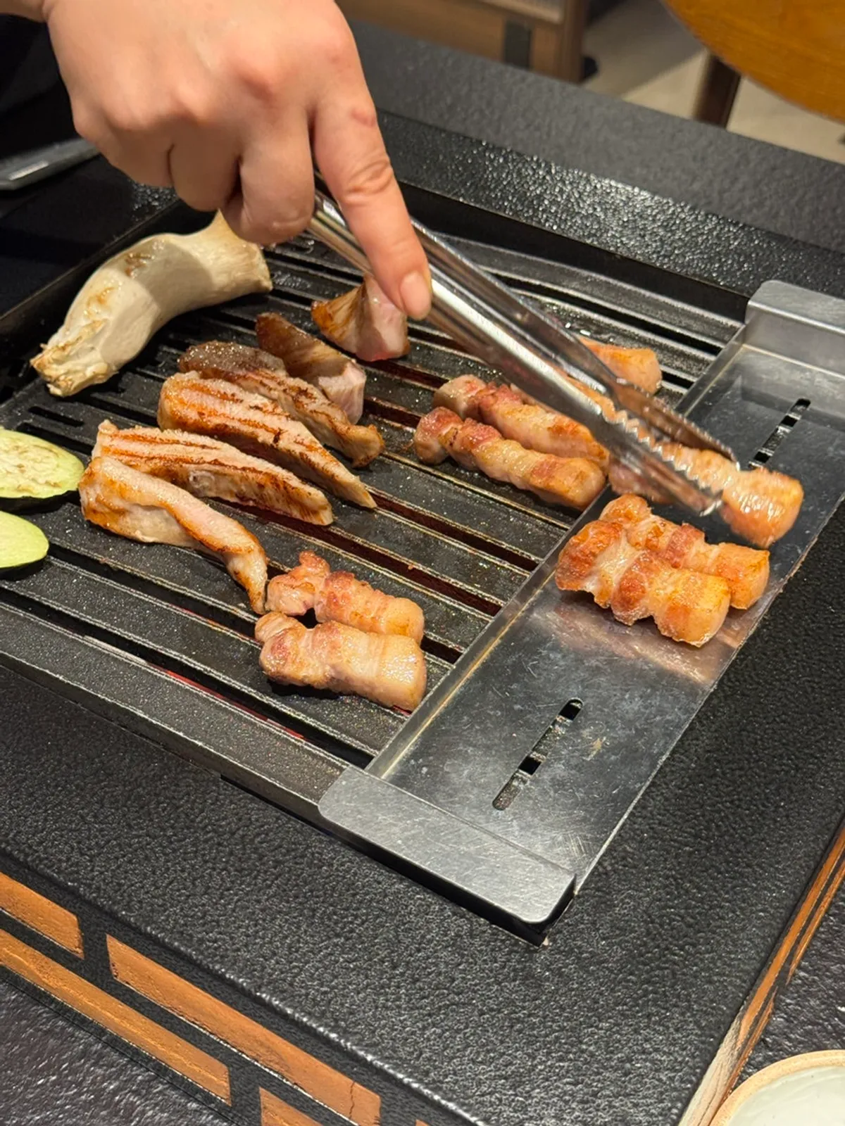 Pork belly and pork jowl grilling over charcoal