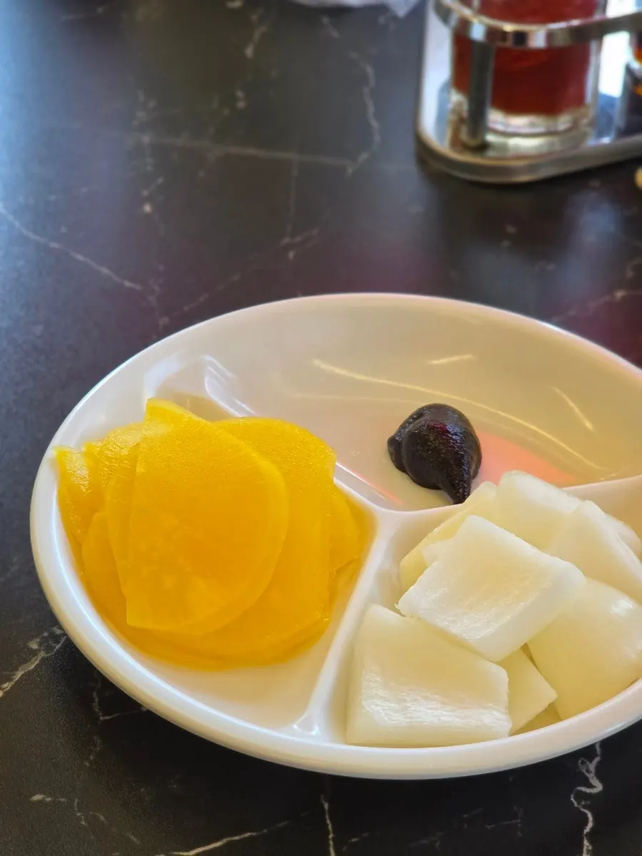Pickled radish and onion side dishes served after ordering