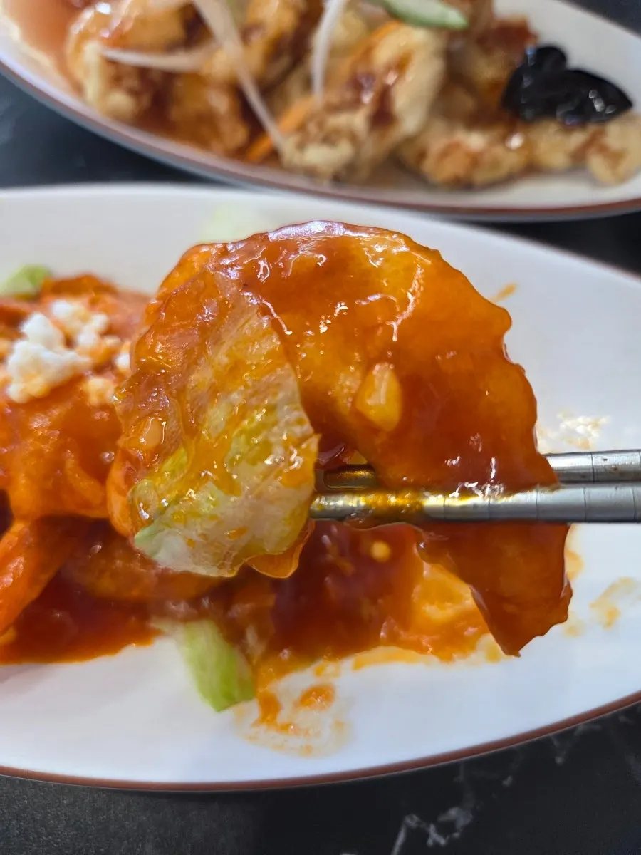 칠리새우 한 점을 집어 든 모습