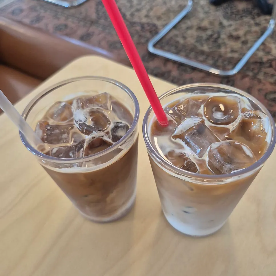 Iced latte and dessert plate on the table