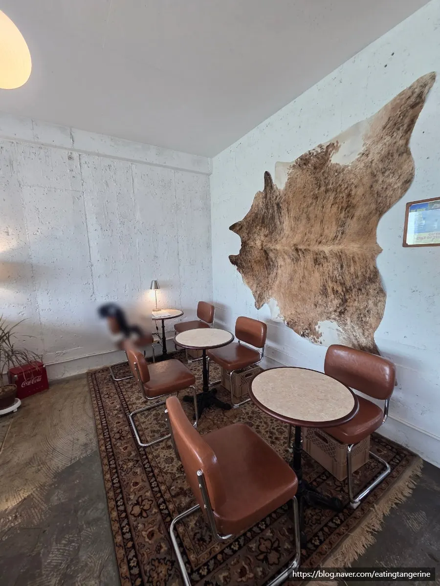 Plush sofa and chair seating in front of floor-to-ceiling windows