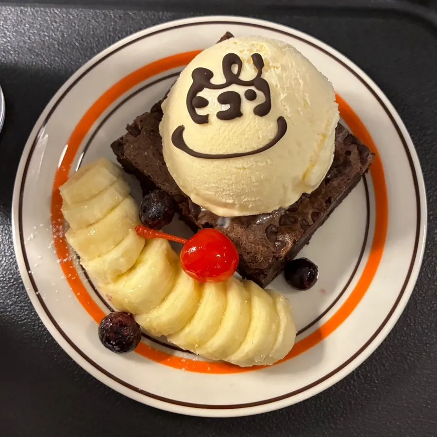The Hongrad Brownie with a chocolate-syrup face drawn on top