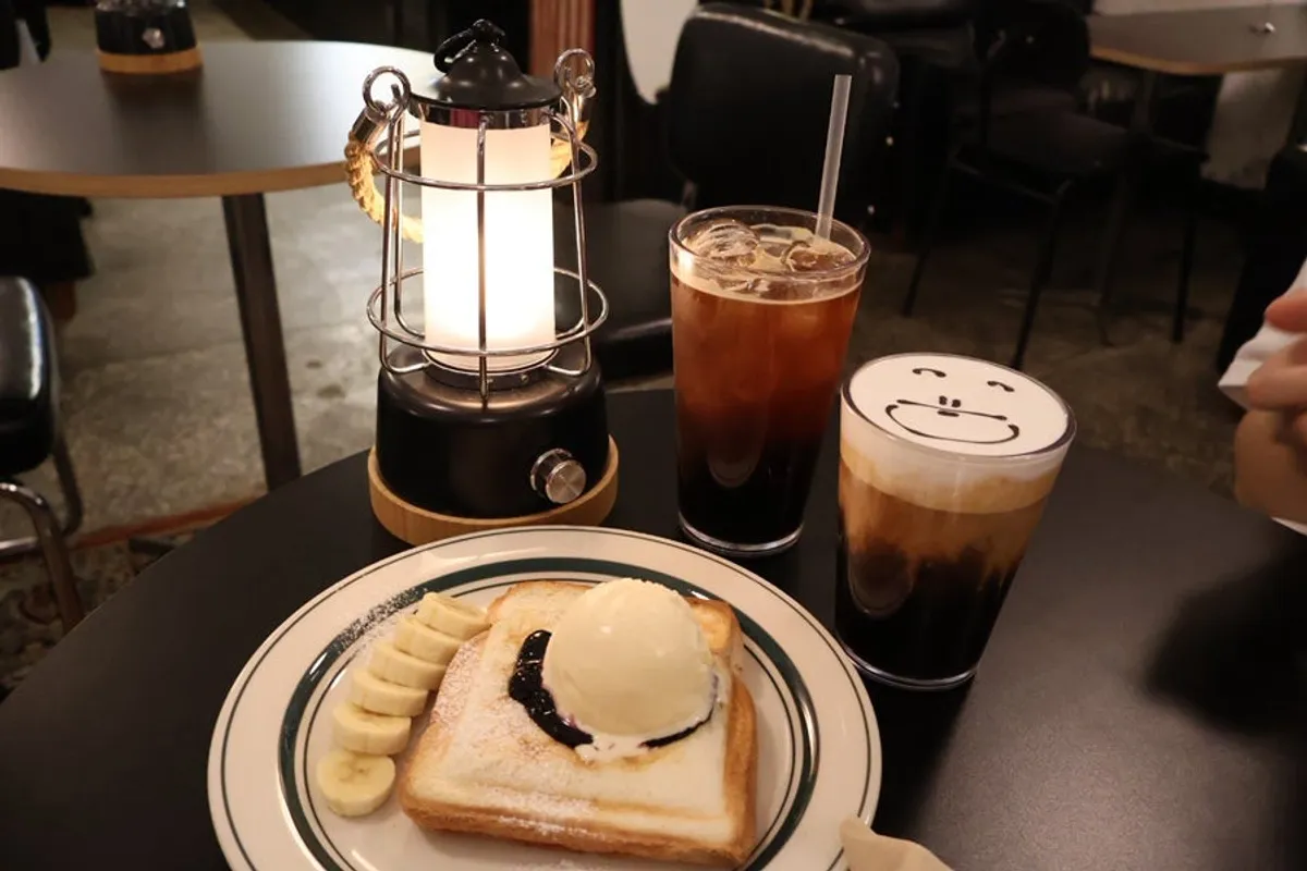 Table setting with bear einspänner, iced Americano, and ex-boyfriend toast